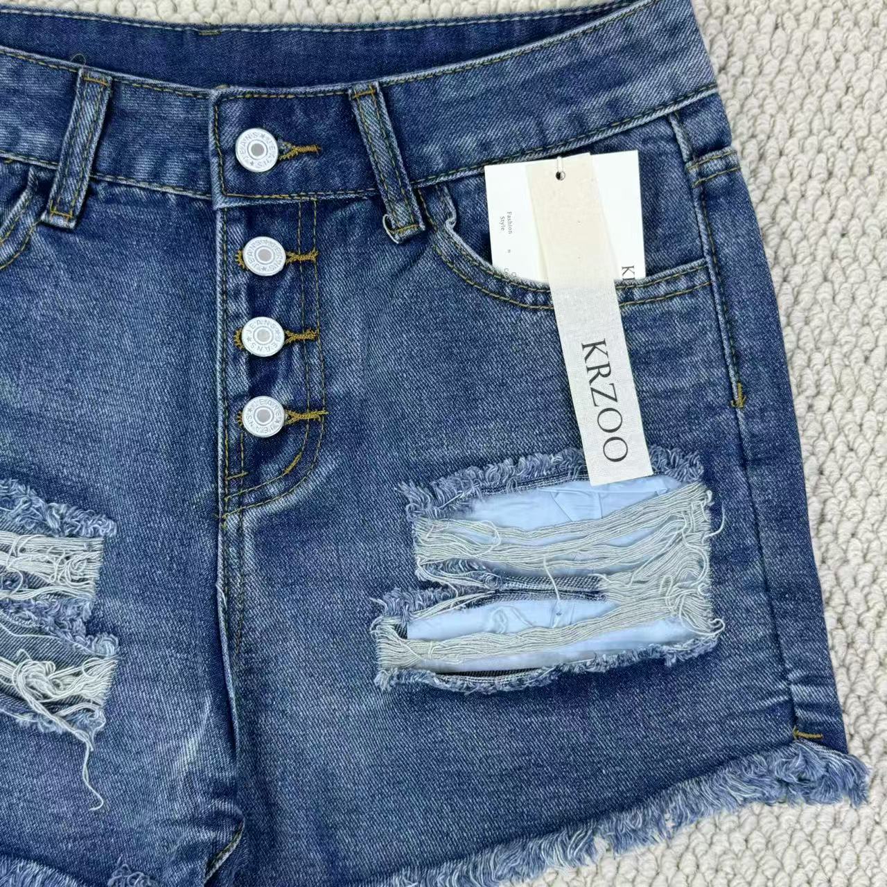 Hole-rimmed fringed denim shorts