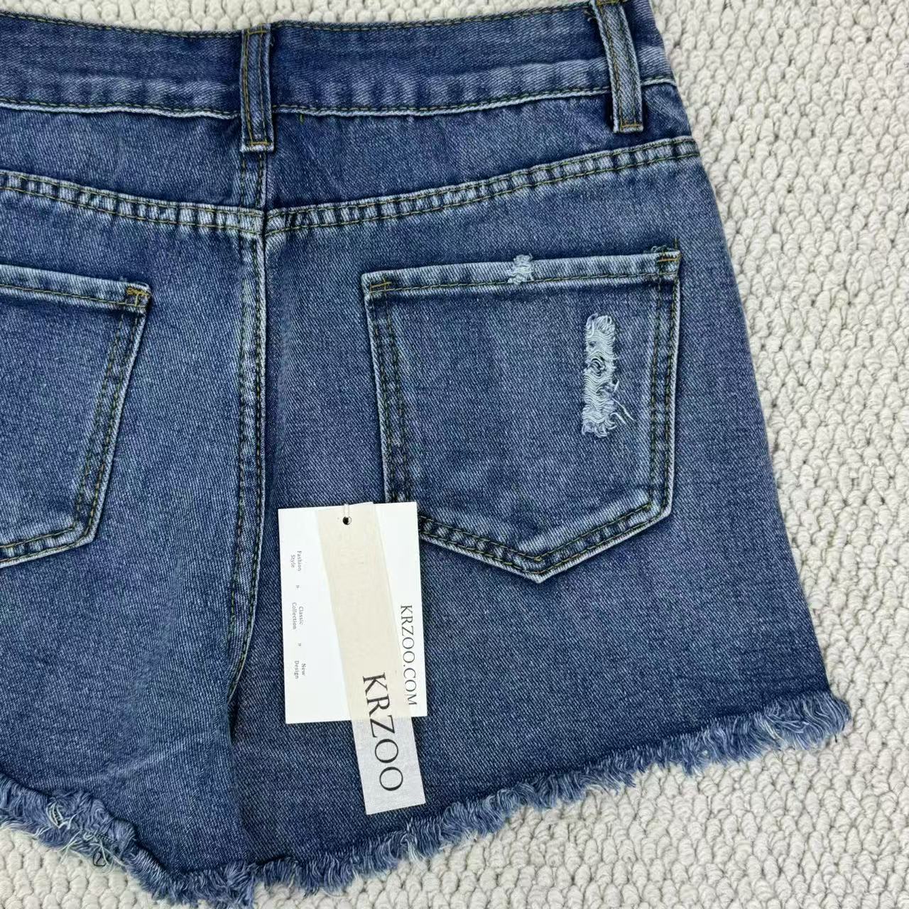 Hole-rimmed fringed denim shorts
