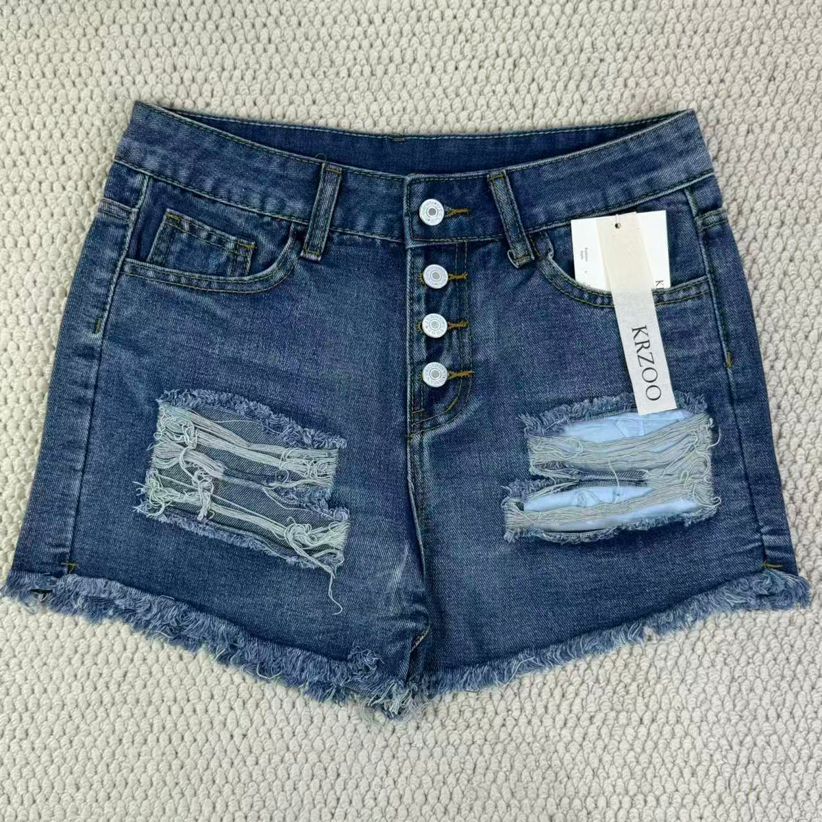 Hole-rimmed fringed denim shorts