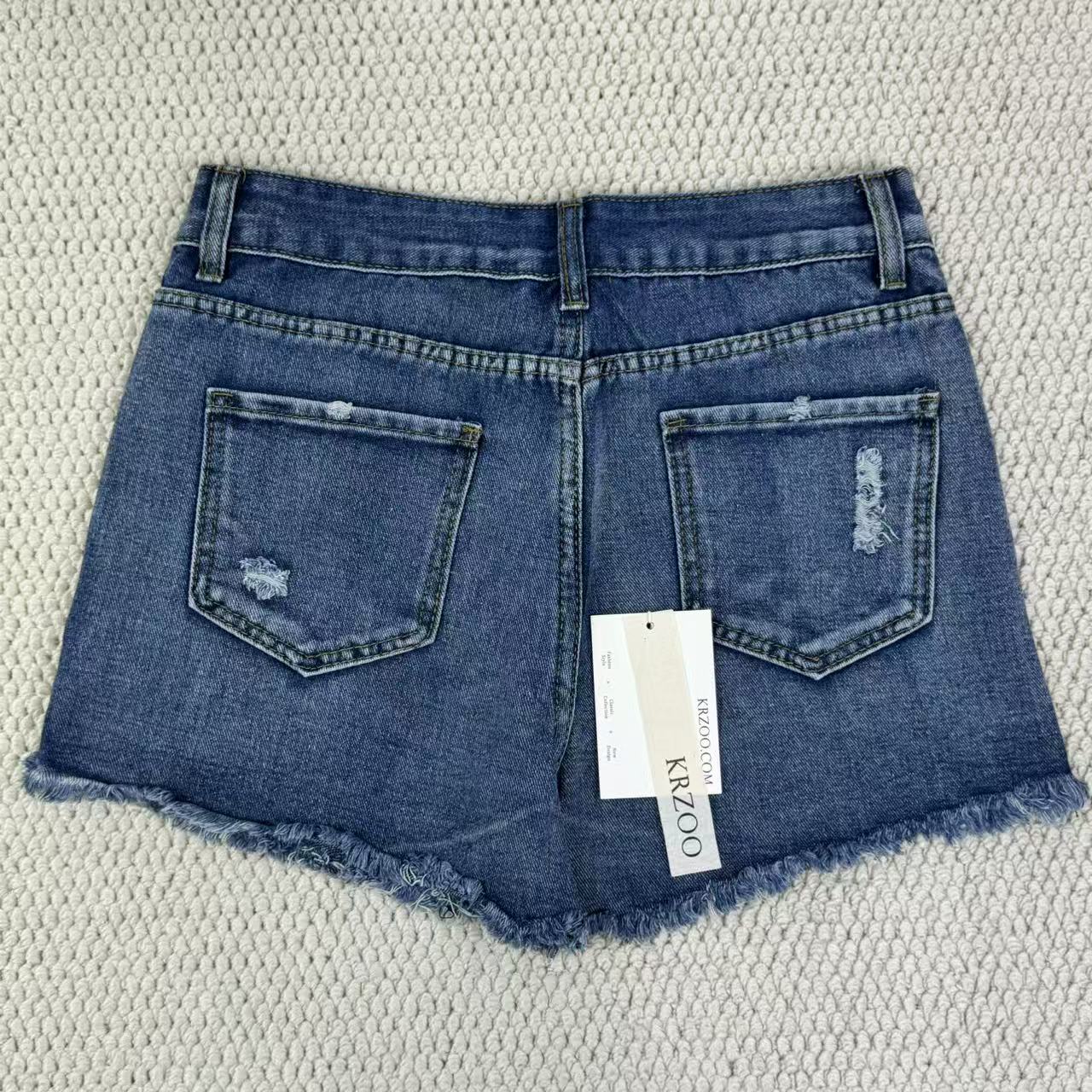 Hole-rimmed fringed denim shorts