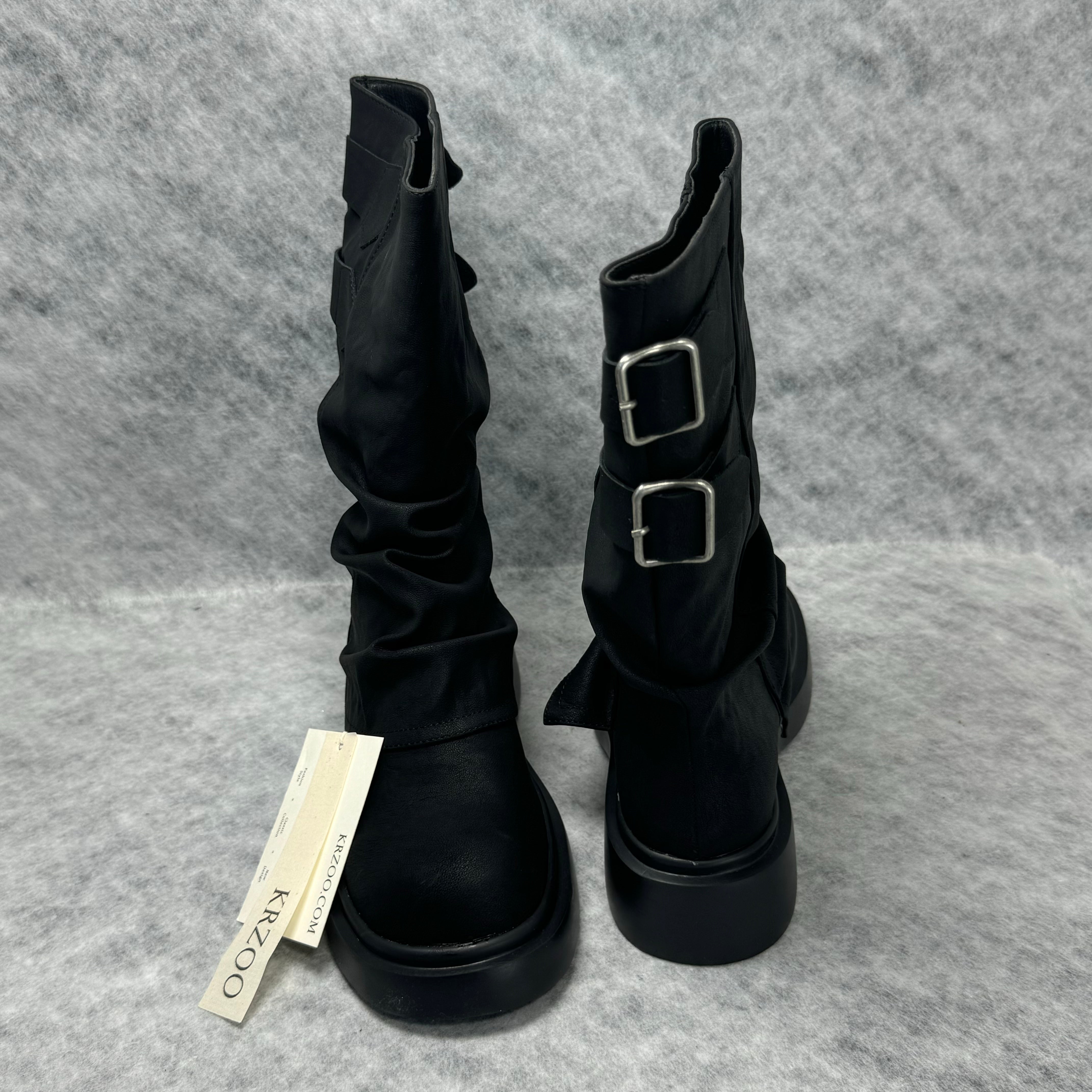 Stacked boots in a creased heap