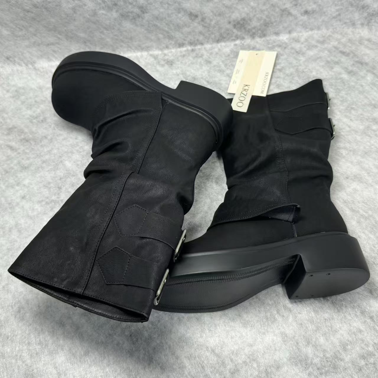 Stacked boots in a creased heap
